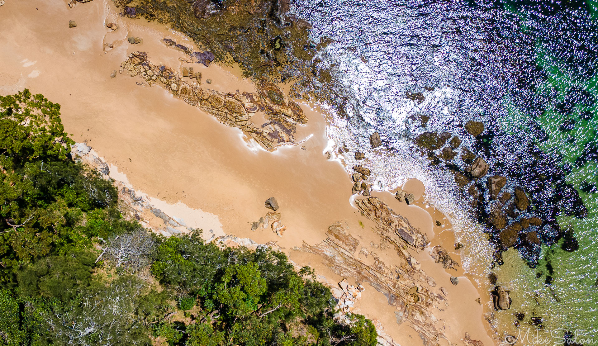 Nature's taste in art: direct  down view of the water, the rocks, the sand and the bush, at Bundeena. [0156]
