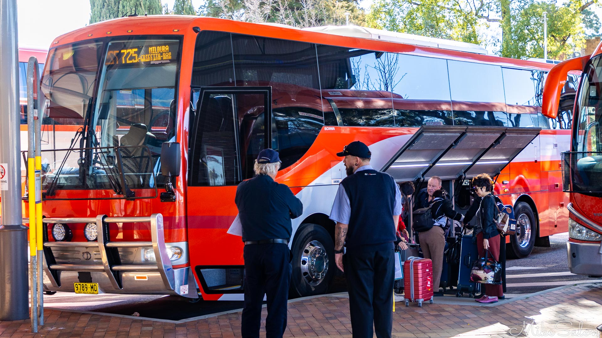 Bright red coach to Mildura, passengers loading luggage. [5087]