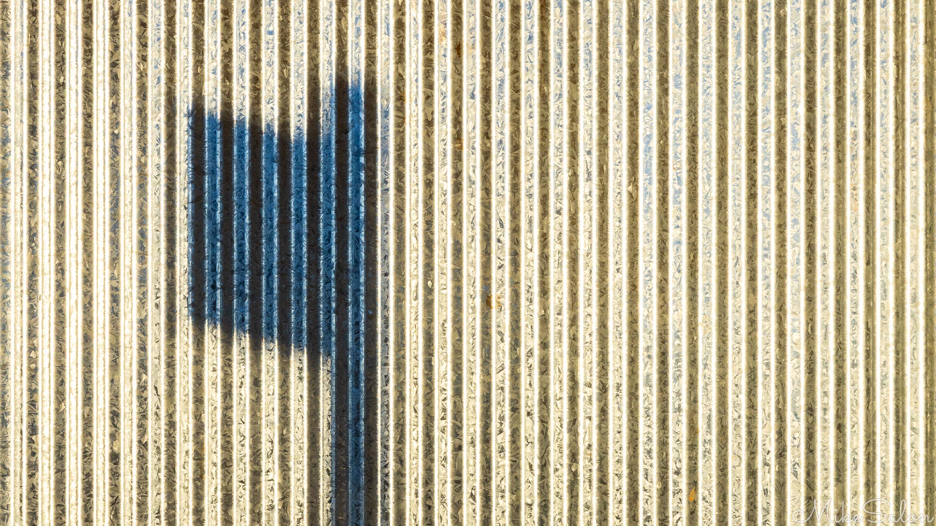 Artistic shot of a sign's shadow on a corrugated wall. [5054]