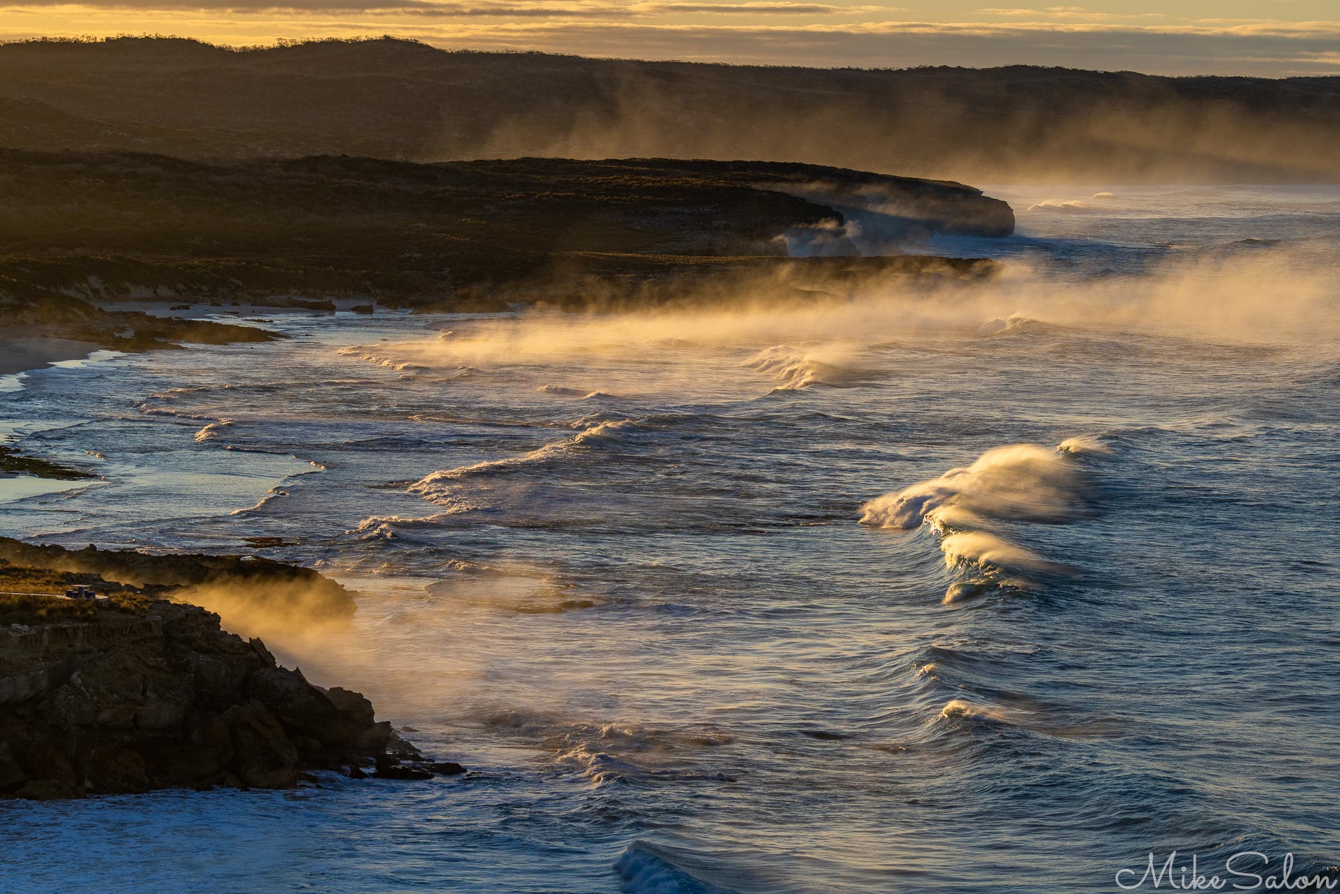 Sunrise view of a rough surf bay showing fog and foam. [3586]