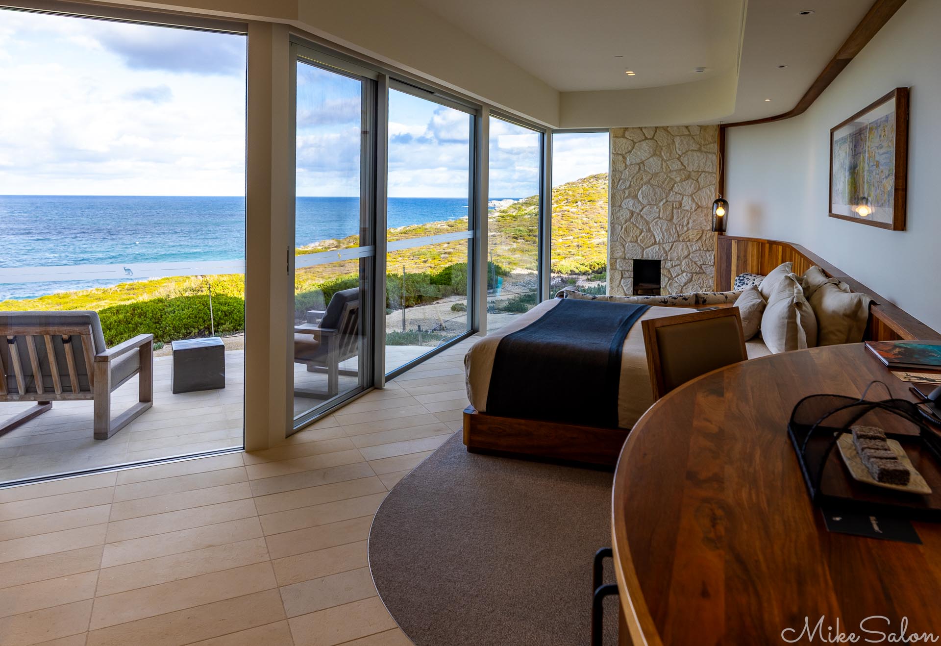 Interior of a lodge guest suite, showing a patio and the ocean beyond. [3391]