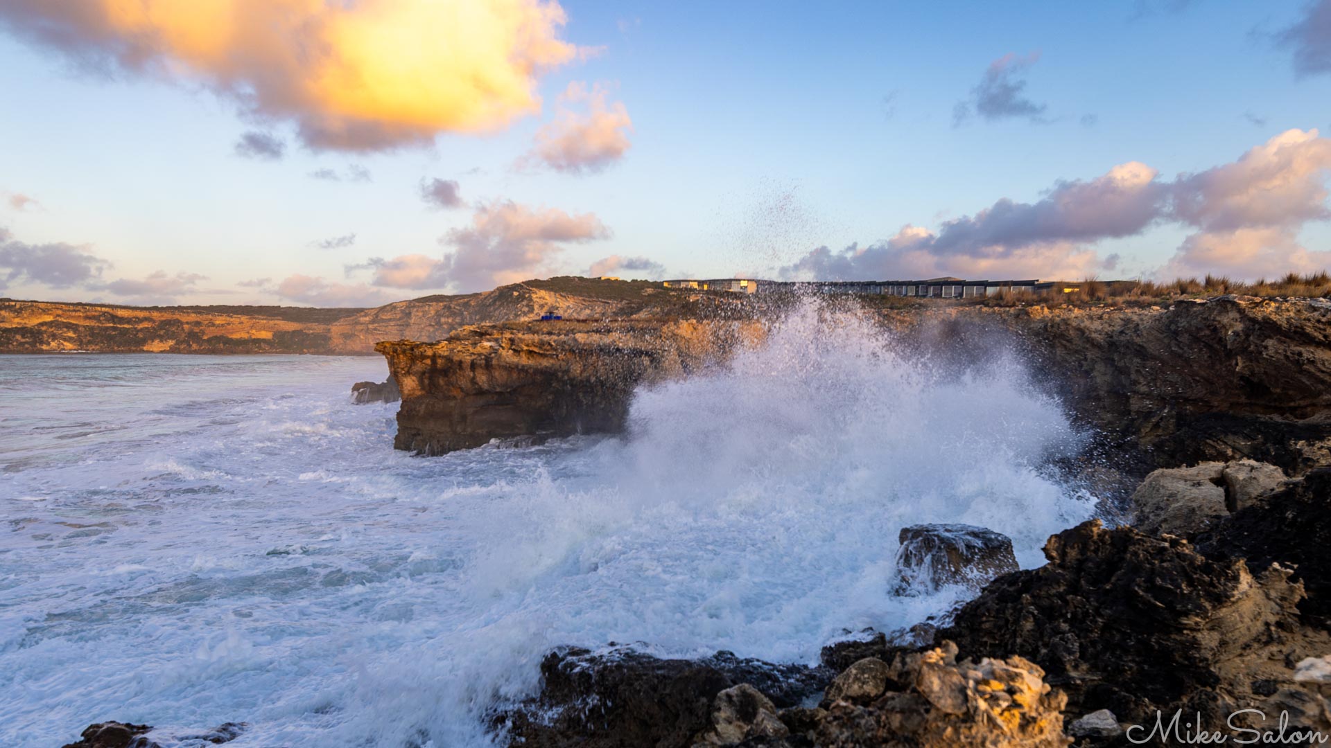 Post-dawn view of big seas splashing onto a rocky cliff-face. [4288]