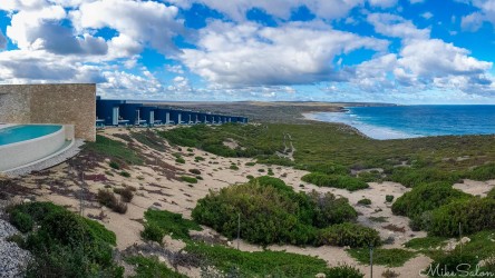 Lodge buildings stretches out in the distance, pool or left, sand dunes, and ocean on right. [3053]
