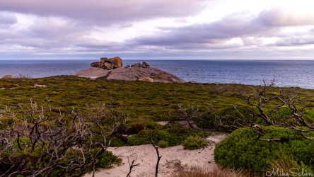 From a distance, the granite dome of the Remarkables, ocean and cloudy sky behind. [3536]