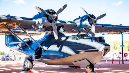 This Catalina is one of the amphibious flying boats used by Qantas Empire Airways during and after World War II. These aircraft were vital to maintaining long‑distance air links when normal routes were disrupted by the war. The Catalinas operated a service between Perth and Ceylon (Sri Lanka), flying non‑stop for up to 32 hours across the Indian Ocean — the longest regular air route in the world at the time. The turret on the starboard rear side a remnant of its wartime configuration, retained during restoration to show how these aircraft were armed for patrol and reconnaissance. [0990]