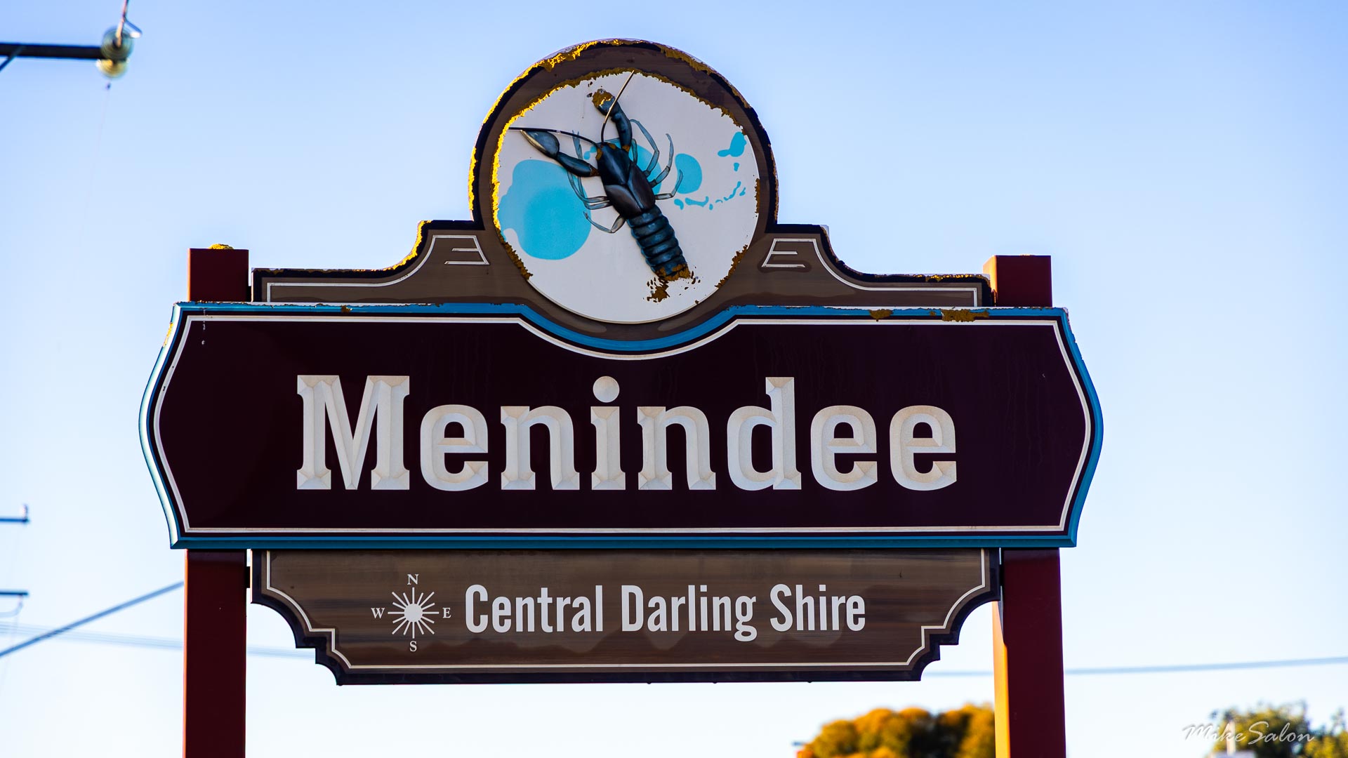 Menindee town sign with crayfish emblem and Central Darling Shire text.