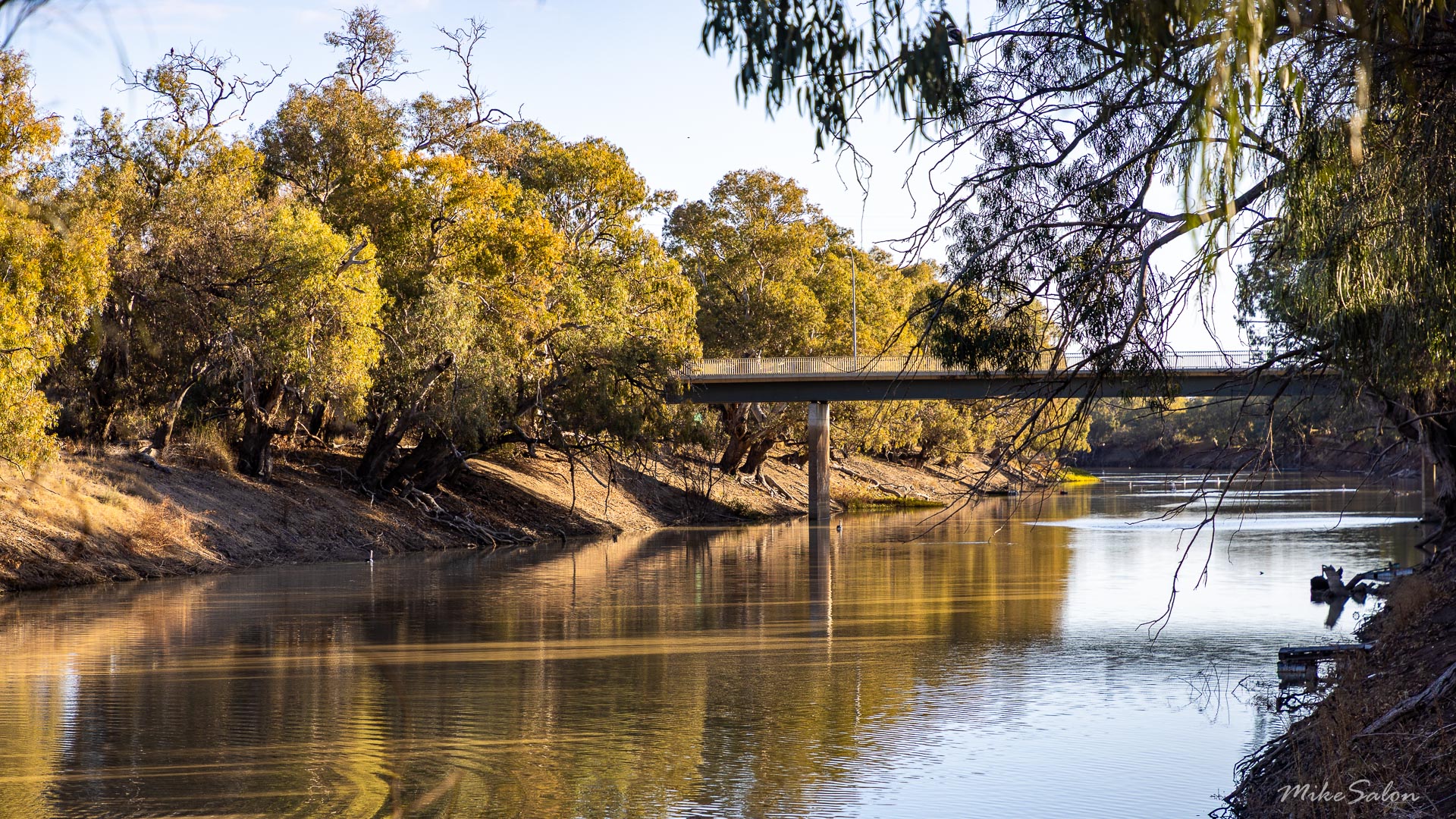 Bridge crossing the Darling River with river gums and calm water.