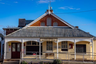 Gabled heritage‑style building with veranda and tin roof.