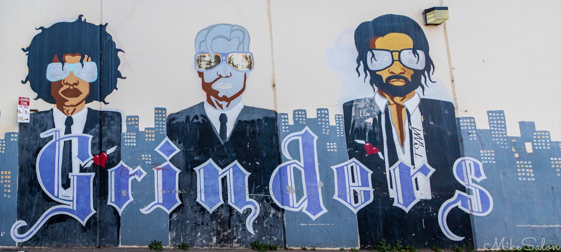 Painted mural showing stylised men in suits with "Grinders" lettering.