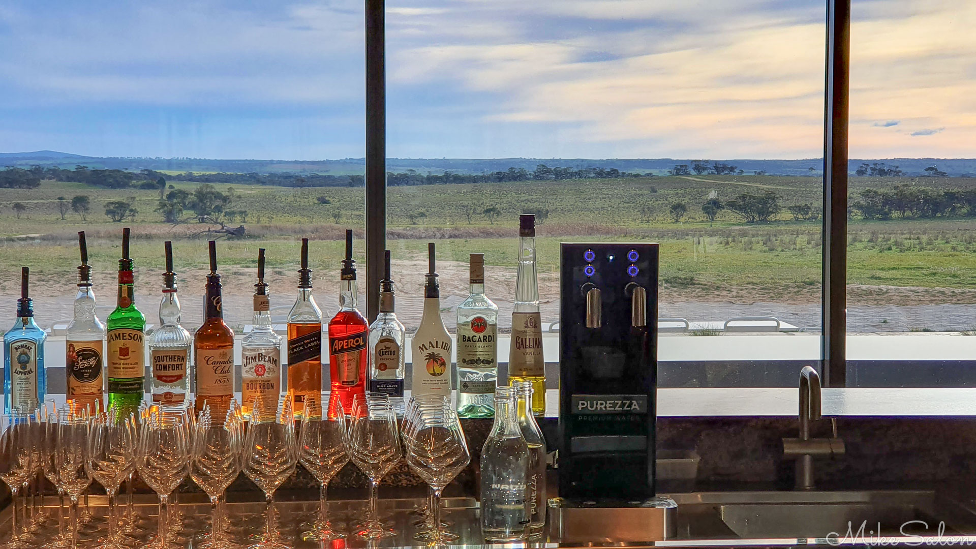Lineup of alcohlic spirits in a bar looking out to a view of the Zoo. [4535]