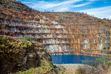 The distinctive stepped benches were created by a method called open‑pit bench mining. Each terrace marks a level where rock was drilled, blasted, and hauled away in relative safety. After the mine closed, the pit gradually filled with groundwater.[0873]