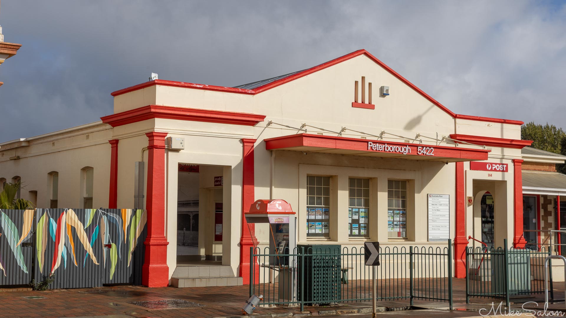 White post office building with red accents and gabled roof.