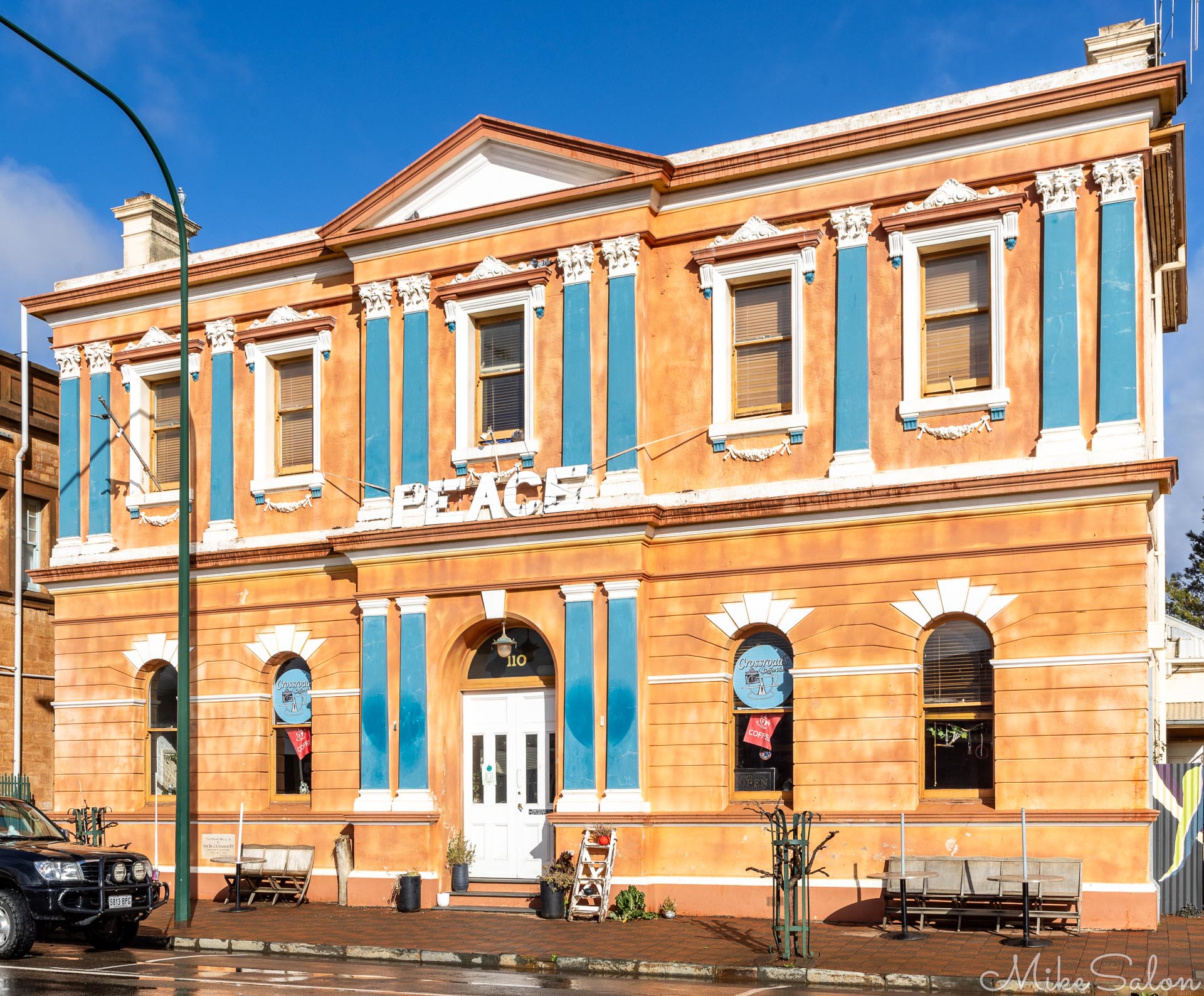 Two‑storey heritage building with tan brickwork and blue detailing.