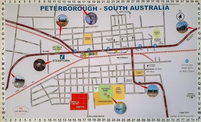 Printed map of Peterborough showing streets, railway lines, and landmarks.