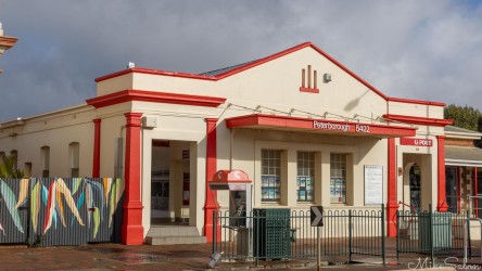White post office building with red accents and gabled roof.