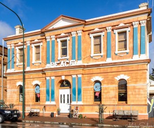 Two‑storey heritage building with tan brickwork and blue detailing.