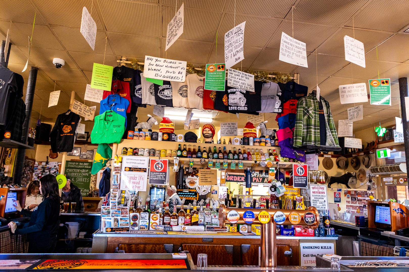 Interior of Silverton Hotel bar with merchandise, hanging items, and counter filled with goods.