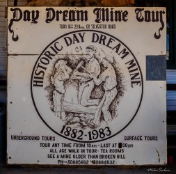 Circular sign reading "Day Dream Mine Tour Historic Day Dream Mine 1882-1983" with illustration of miners and text about underground tours.