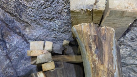 Close‑up of wooden supports against rocky surface inside mine.