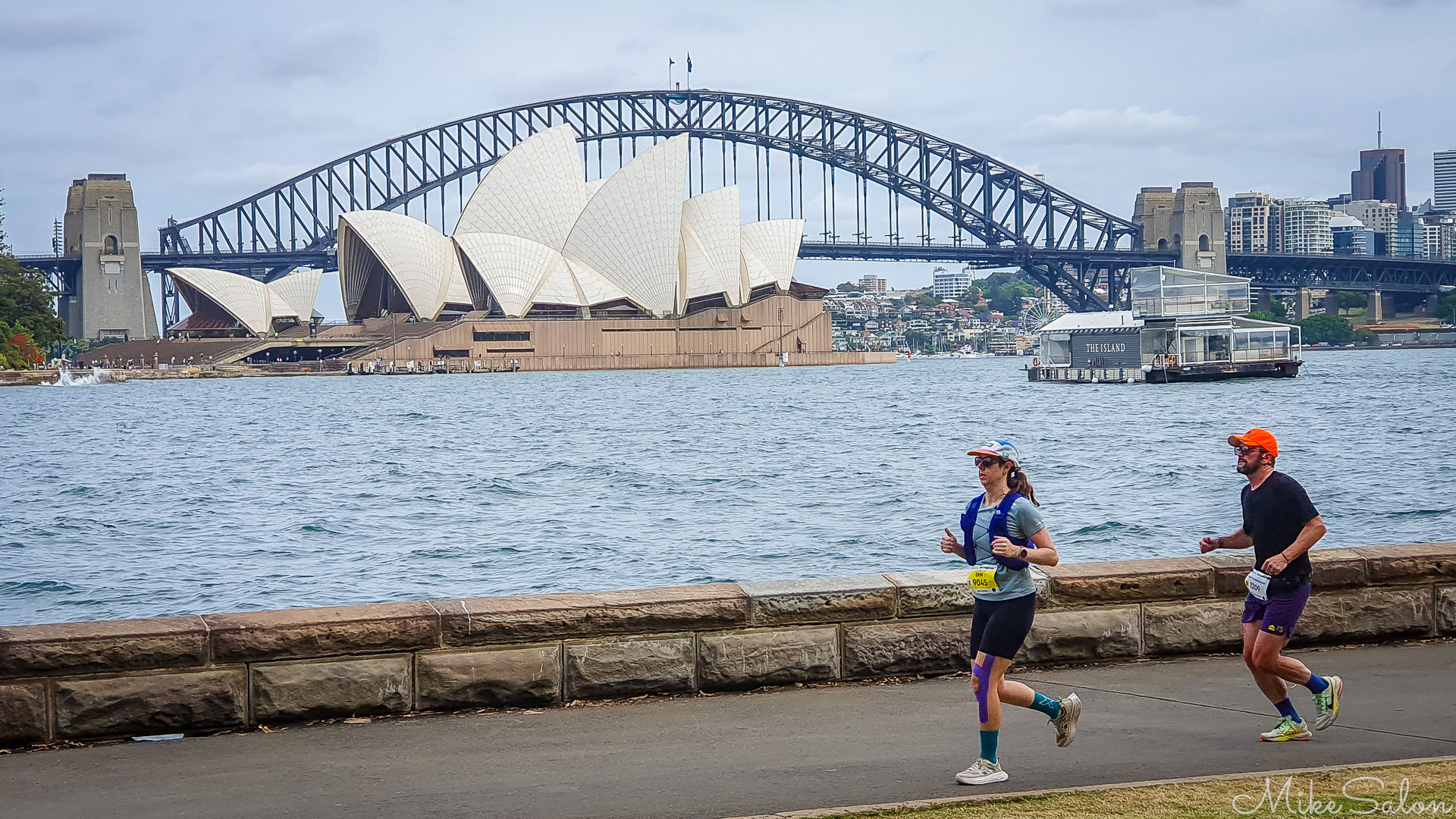 Thumbs up as two competitors run by that iconic view. [2653]