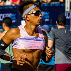 At the 32 km mark, a runner equipped with an action camera and mirrored shades records his own race, every stride measured and deliberate. Technology meets endurance in the heart of Taylor Square. [3968]