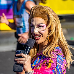 The drag queen MC energises the crowd at Taylor Square, microphone in hand and charisma in full flight, embodying the spirit of Oxford Street’s celebration. [3906]
