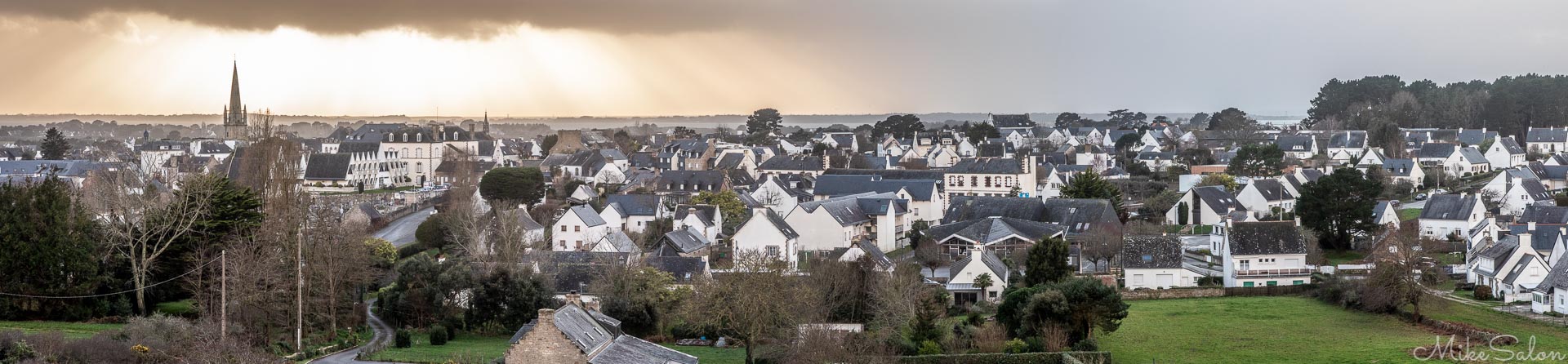 Carnac Cityscape : Sun peeking through the watery view of Carnac township from atop an ancient burial mound. (_D0A3650-Pano.jpg)<br>Camera: Canon EOS 5D Mark IV