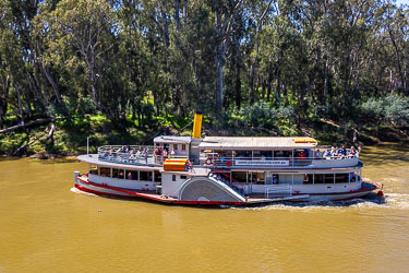 On a notably brown river, the PS Melbourne passing by.