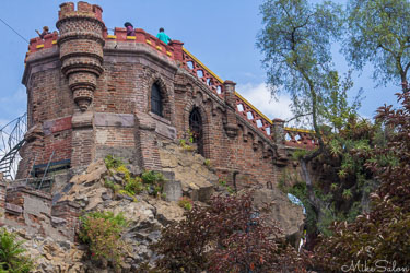 Fort Hidalgo on Santa Lucía Hill in Santiago, Chile, showing stone walls, towers, and greenery under a bright sky.