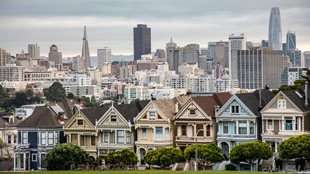 Row of colourful Victorian houses at Alamo Square with San Francisco